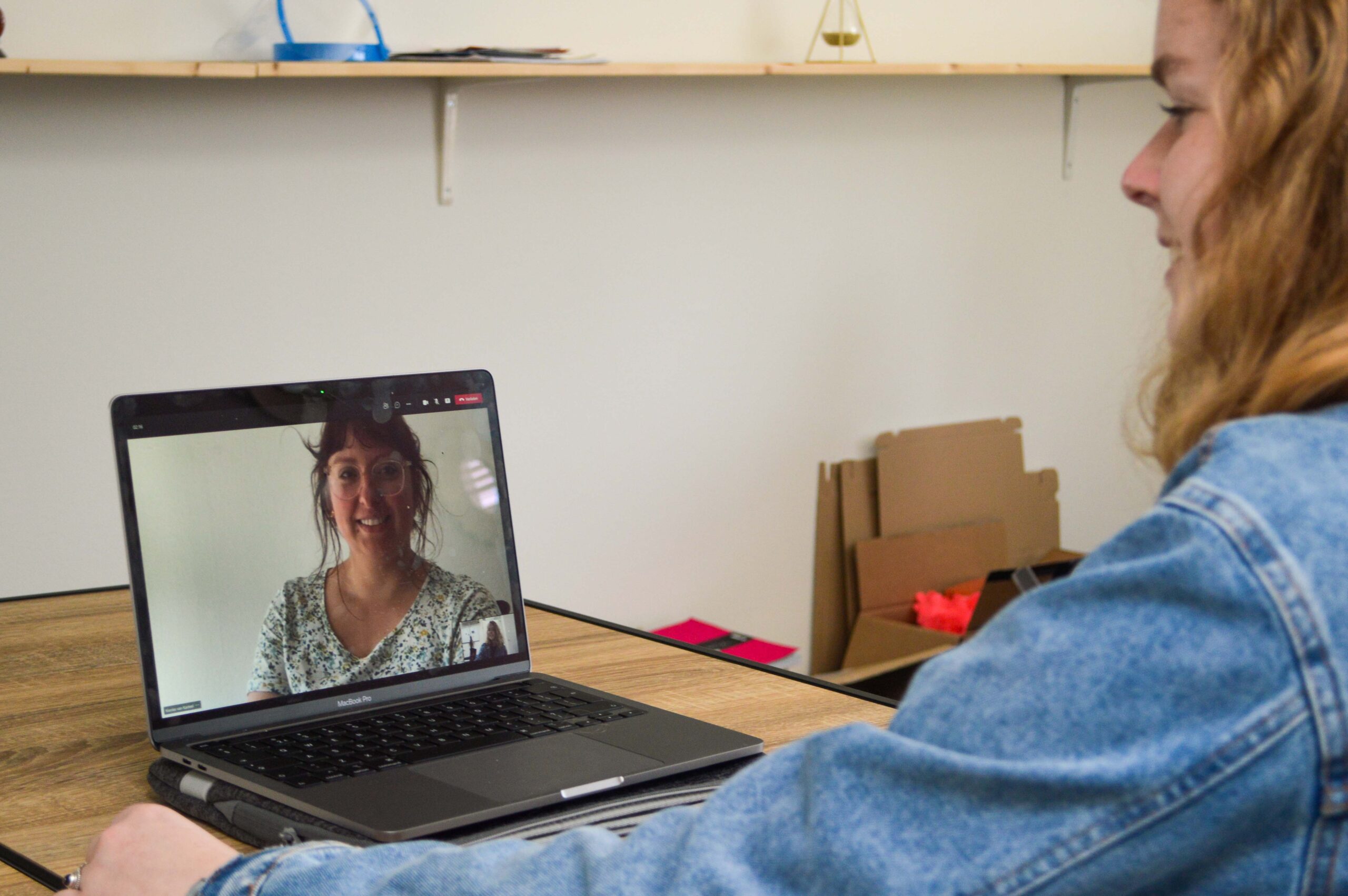 Stagiair achter de laptop, in gesprek met Nienke Kasteel