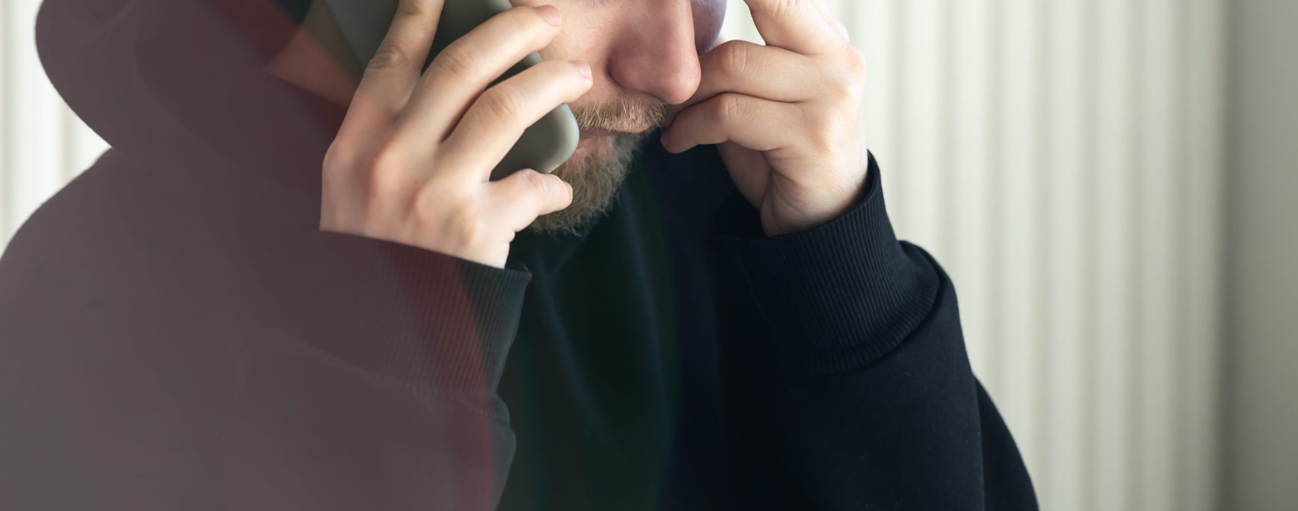 Een man onherkenbaar in beeld, aan de telefoon