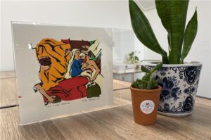 Er is een tafel met links daarop een kunstwerk en daarnaast rechts twee plantjes