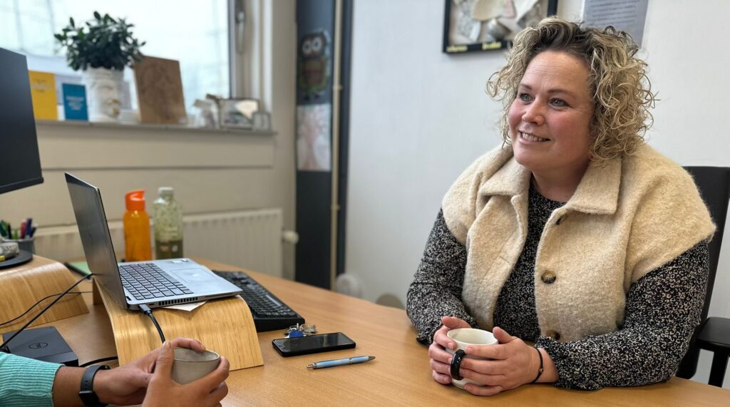 behandelaar in gesprek met cliënt (behandelaar zichtbaar, cliënt anoniem)